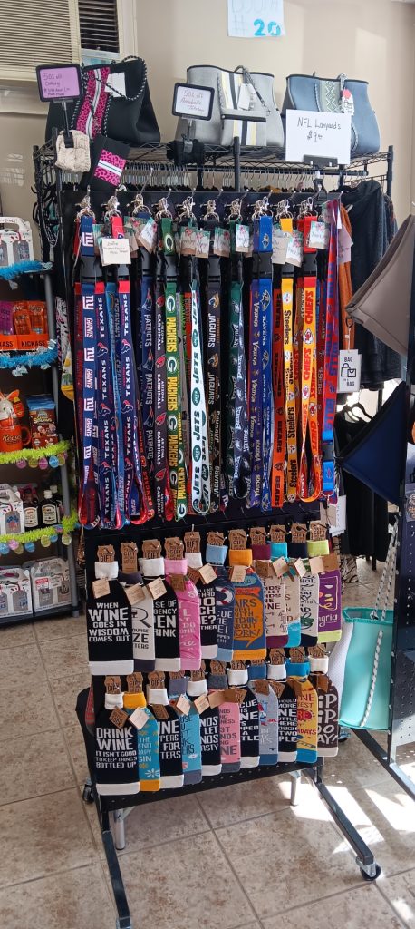 Display has lanyards, wine covers, and hand bags with a variety of colors